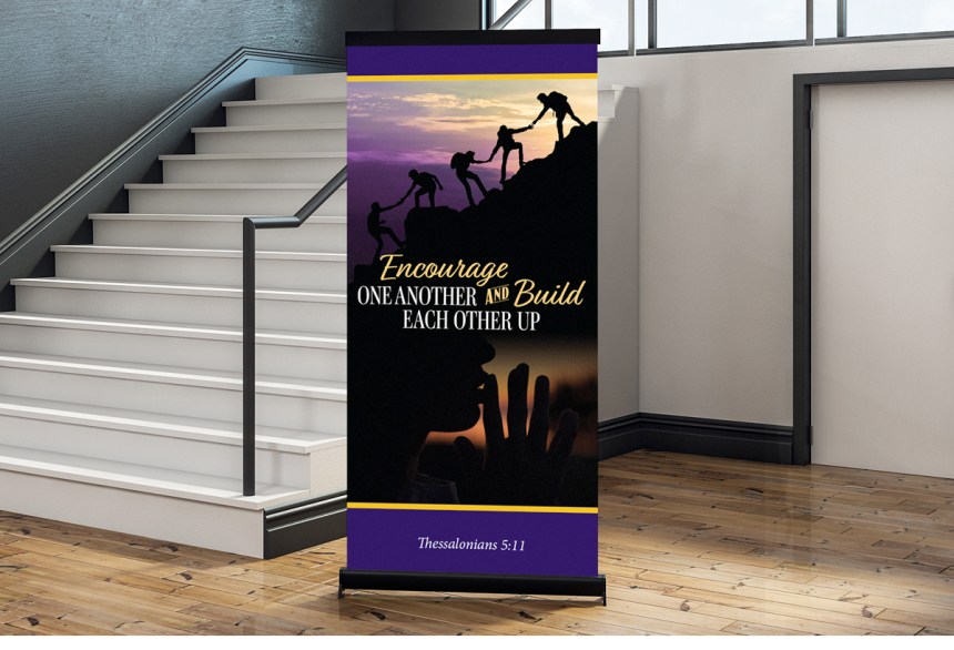 free-standing banner in school hallway with words "Encourage one another and build each other up" (Thessalonians 5:11)